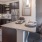 Spacious and well lit kitchen with wood floors and stainless steel appliances. 