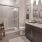Large well lit bathroom with large mirror and brown cabinets 