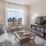 Spacious and well lit living room with wood floors and an open floor plan with access to the kitchen.