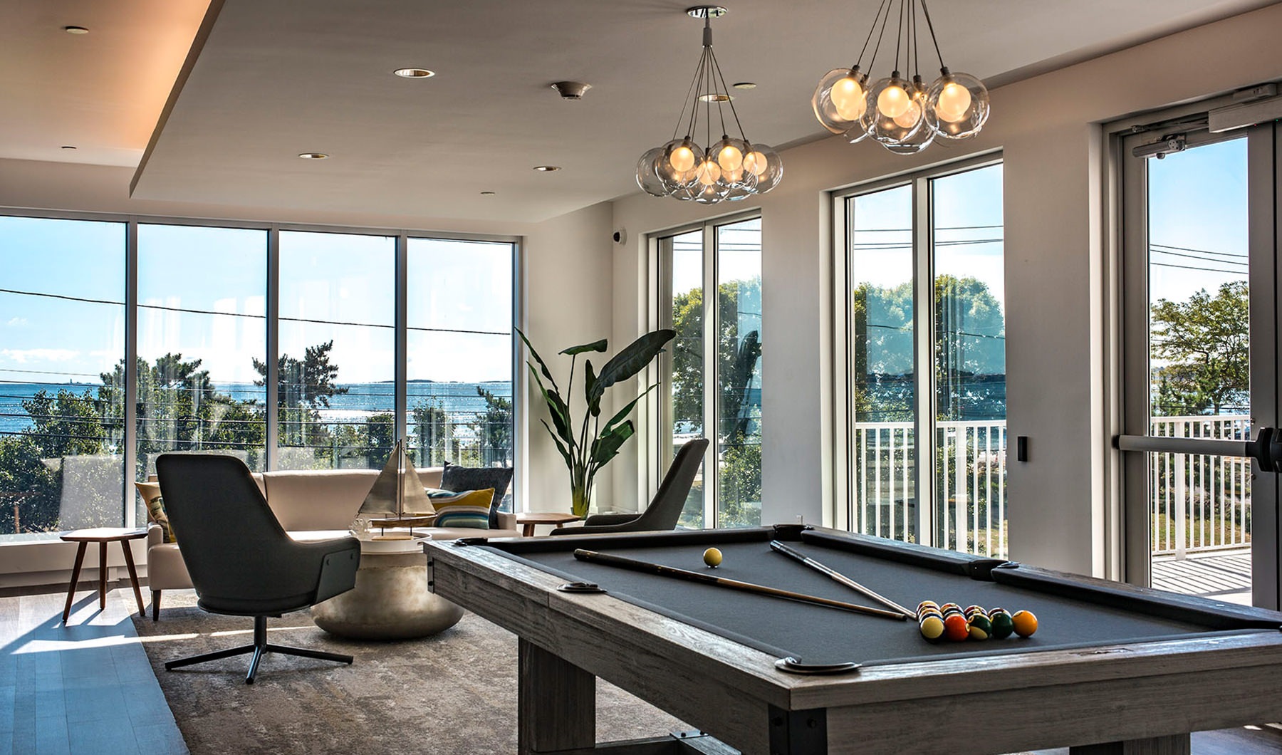 Game Room Spacious and well lit game room with large windows and a pool table
